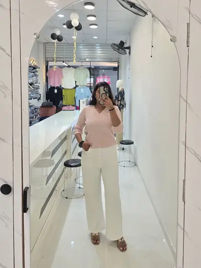 Pink top with white trousers, photographed as a mirror selfie inside Selfie Western Wear